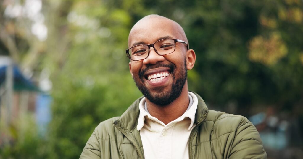 Man smiling outdoors after attending orange drug rehab.
