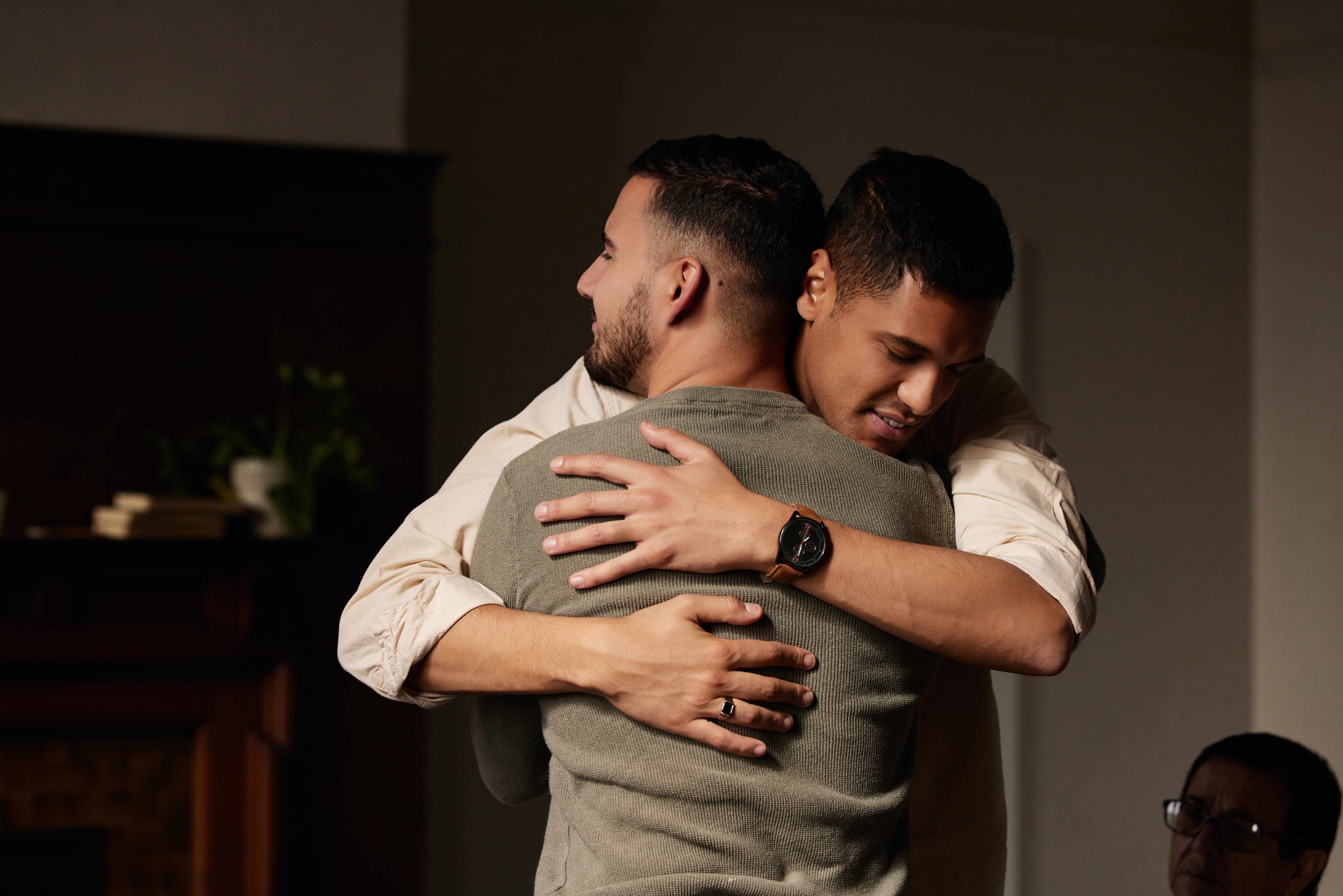 Two men hugging after figuring out what is step 12 in aa​.
